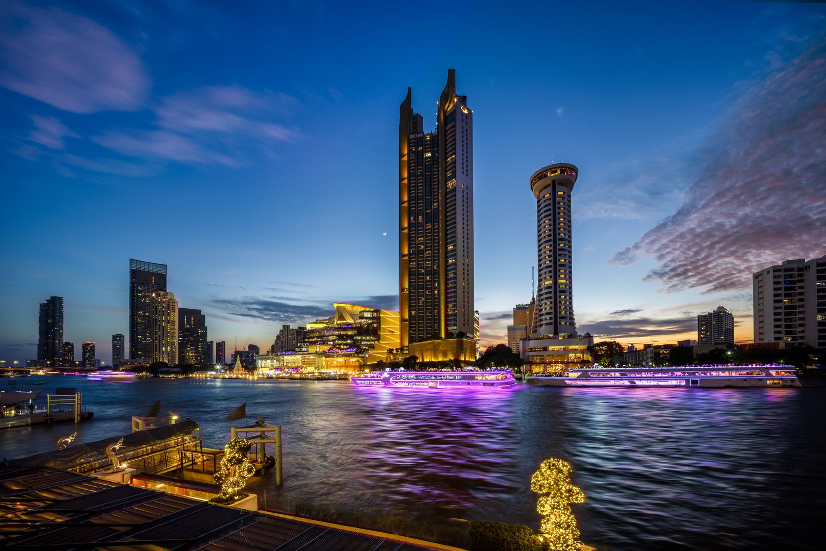 Modern buildings in the city with water reflection, firework, light show at twilight time.