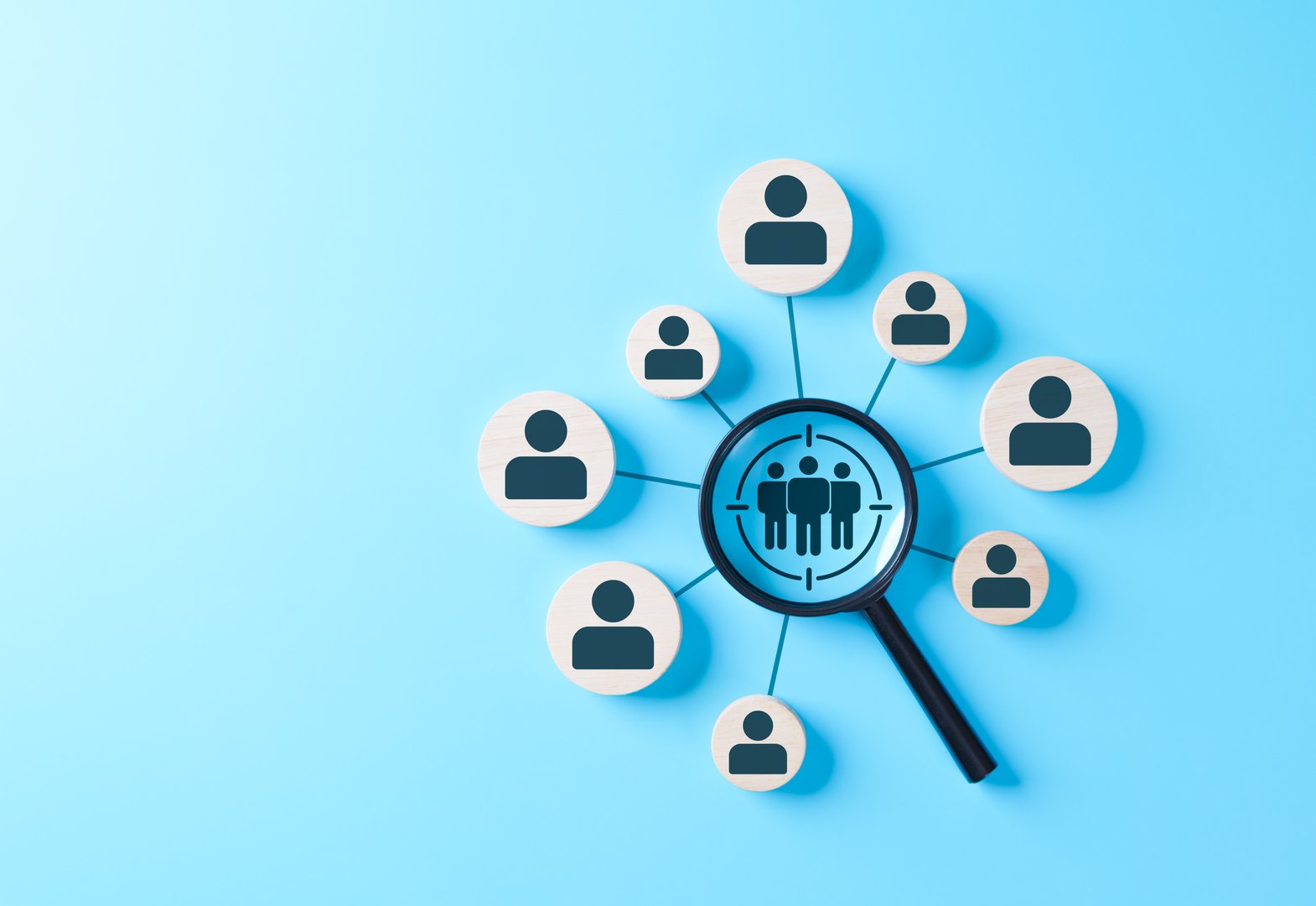 Magnifying glass focusing on target customer group with human icons on blue background, representing business marketing, audience analysis, customer segmentation, recruitment, human resource strategy,