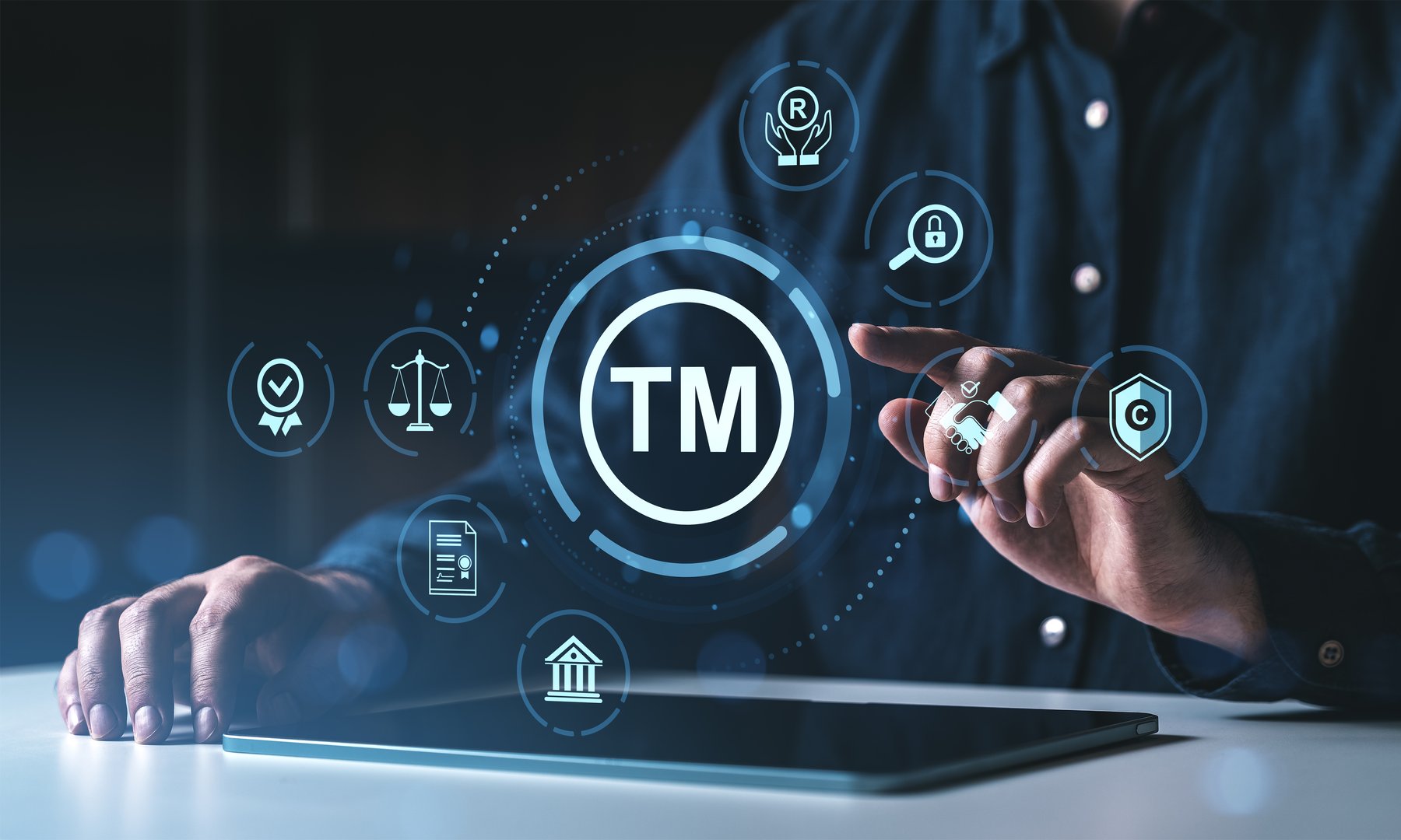Man interacting with trademark protection icons on a digital interface, futuristic style, dark background, concept of legal intellectual property