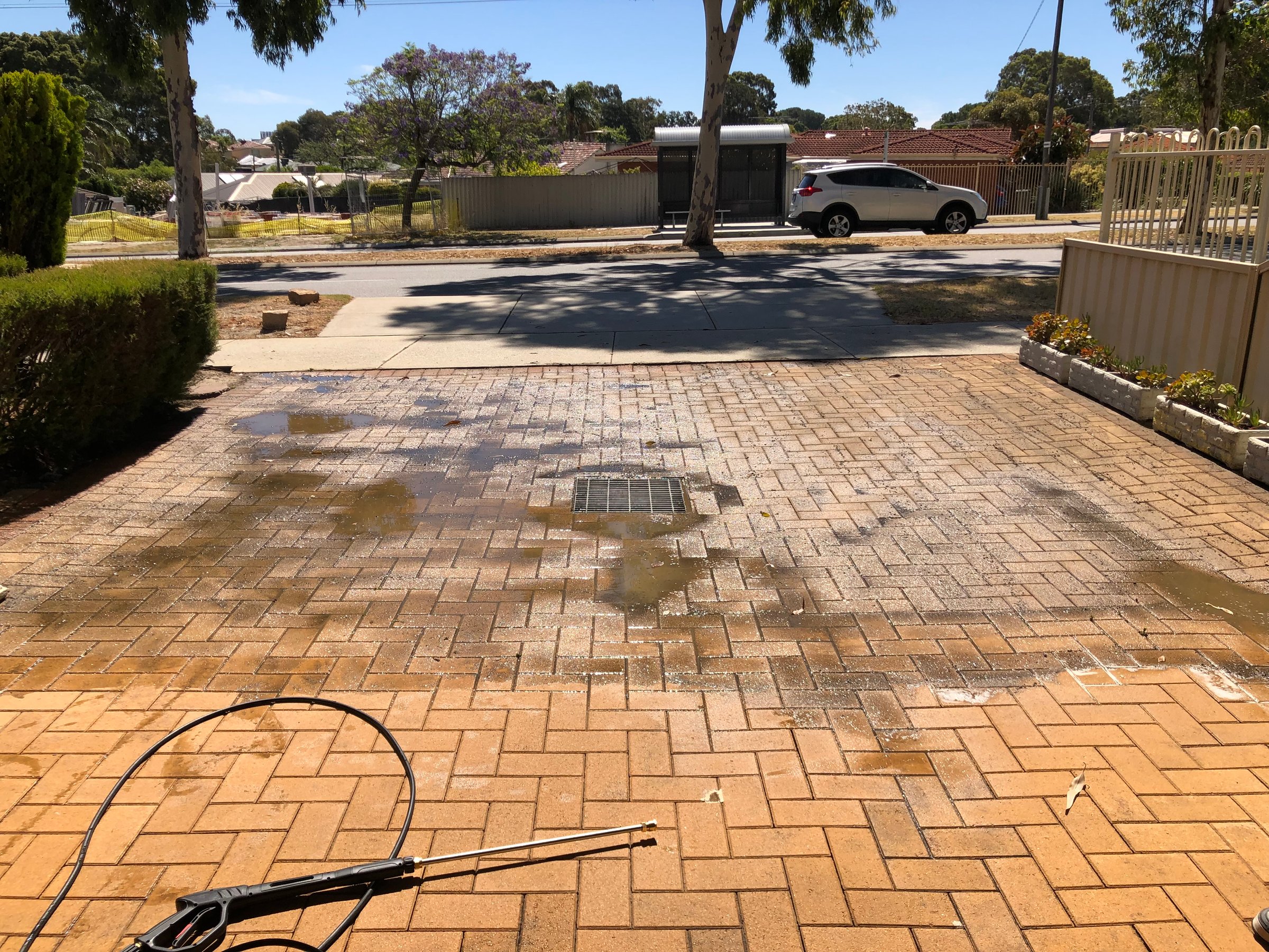 Professional driveway cleaning service showing before and after results