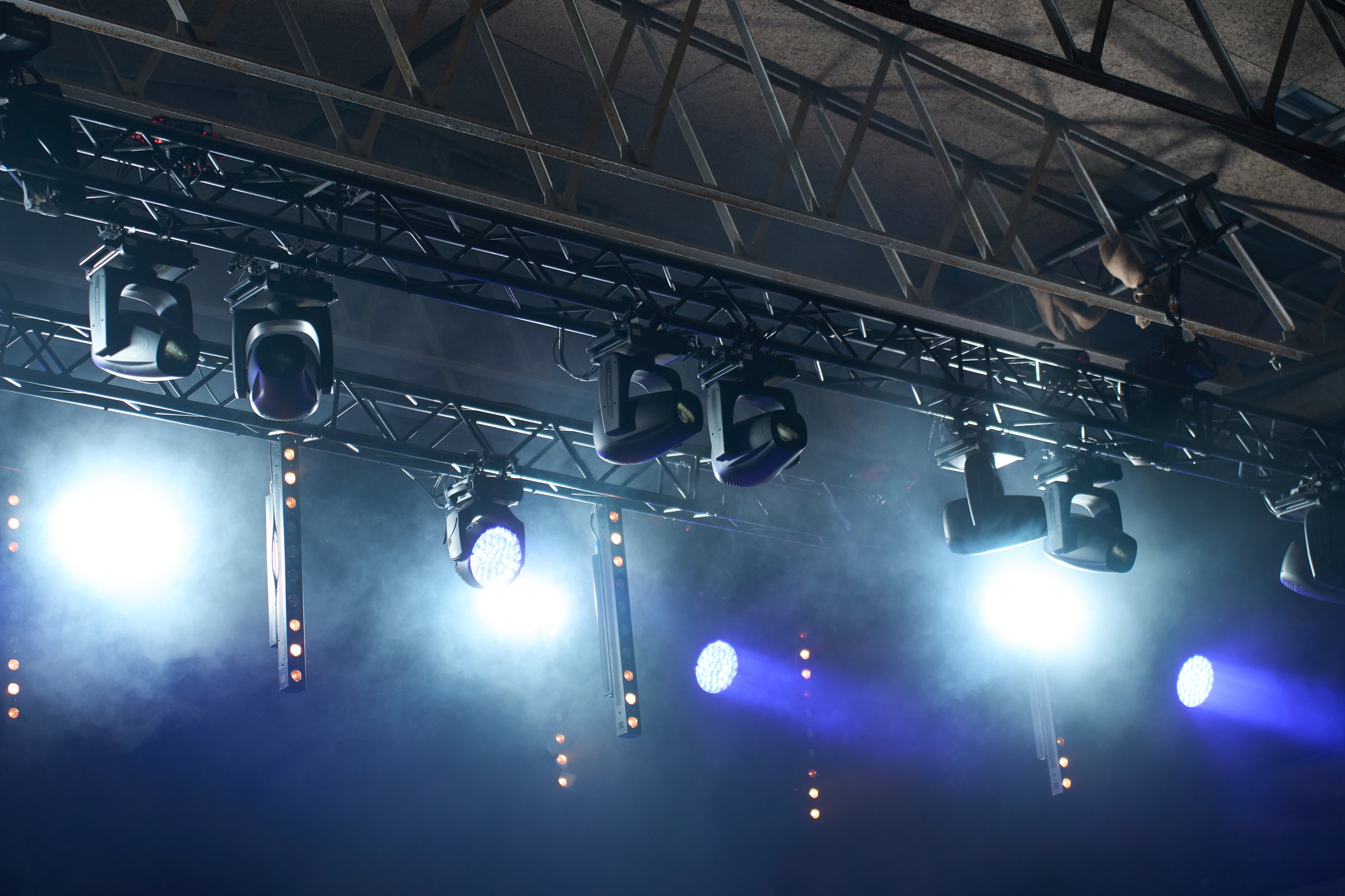 Stage with bright concert lighting, spotlights and smoke effects prepared for live music performance. Illumination for music event