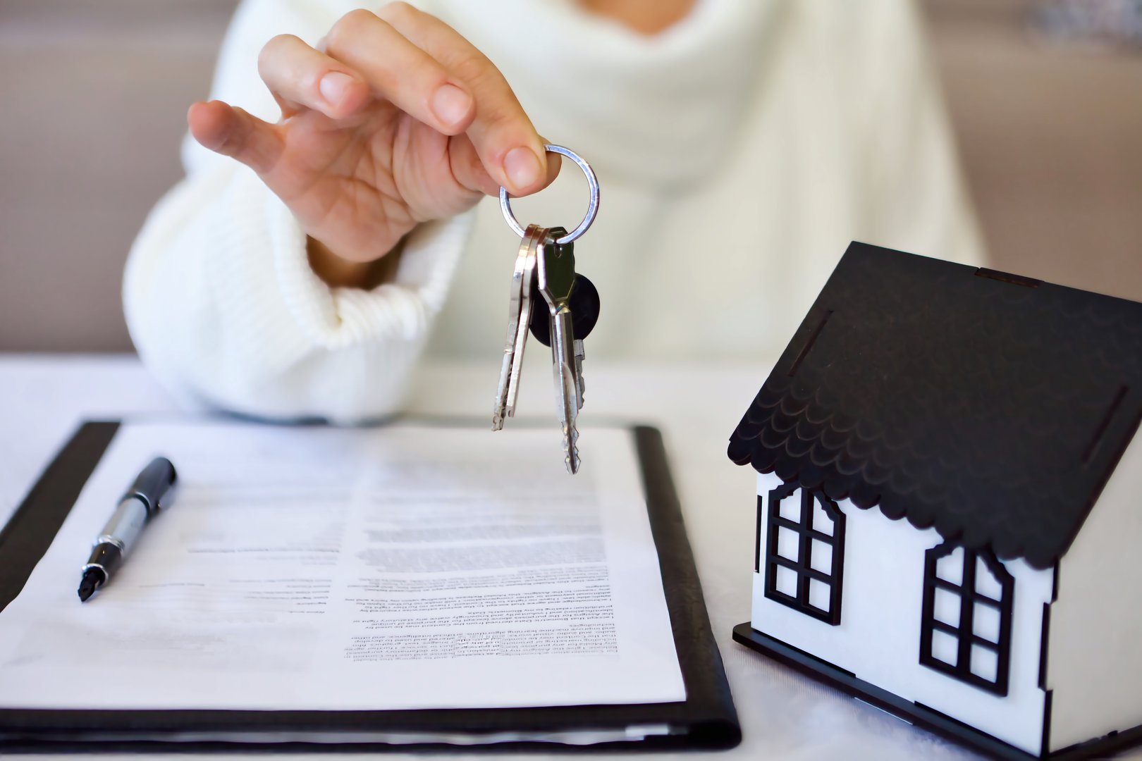 Real estate agent showing the keys of new house to the client.