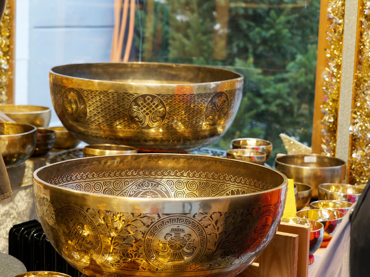 Close-up of  Tibetan singing bowls with detailed engravings, displayed in a calm and warm setting.