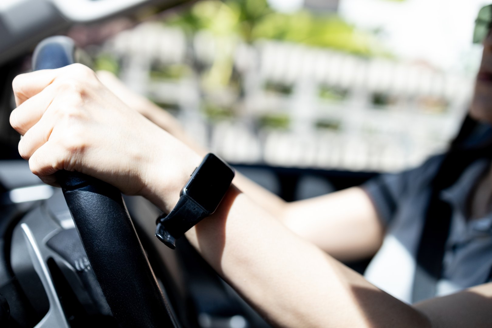 La luz del sol brilla en los brazos y las manos de una mujer que conduce un coche, concepto de película para ventanas, película automotriz, reduciendo el riesgo de daños en la piel, luz solar de bloqueo y radiación infrarroja, rayos ultravioleta del sol