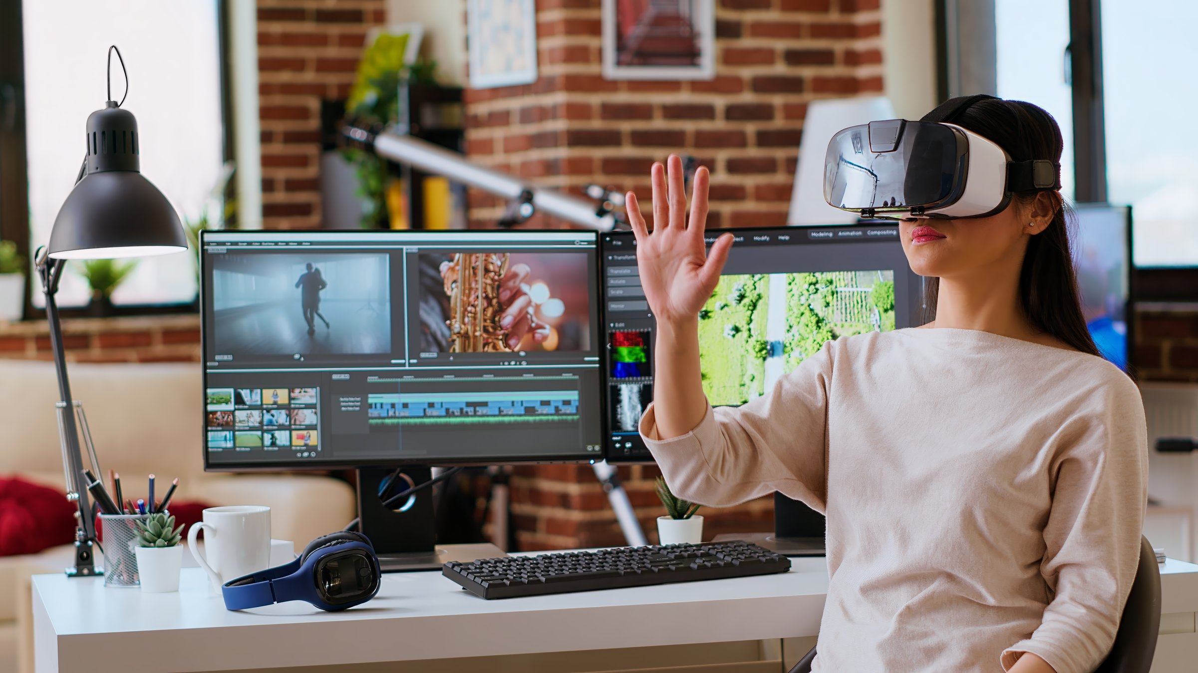 Asian modern editor using virtual reality glasses and mixing video clips, using interactive gadget vr headset to edit and do color grading for a montage. Video editing software. Camera B.