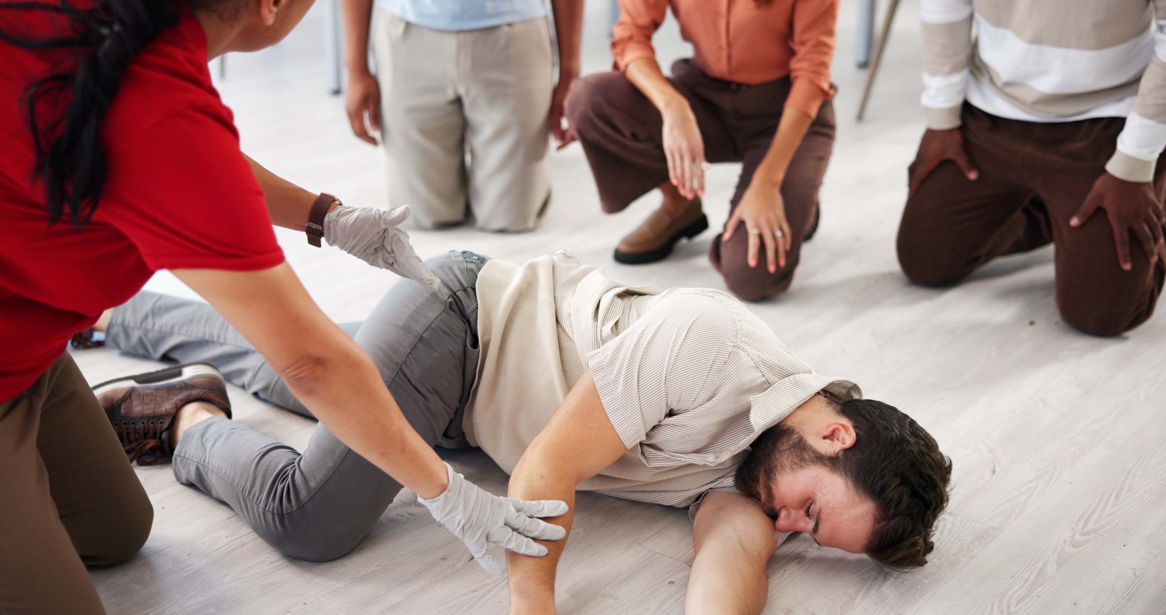 People, demonstration and class for first aid, teaching and learning for healthcare in office and instructor. Life saving, safety and training of employees for CPR, teacher and technique for group