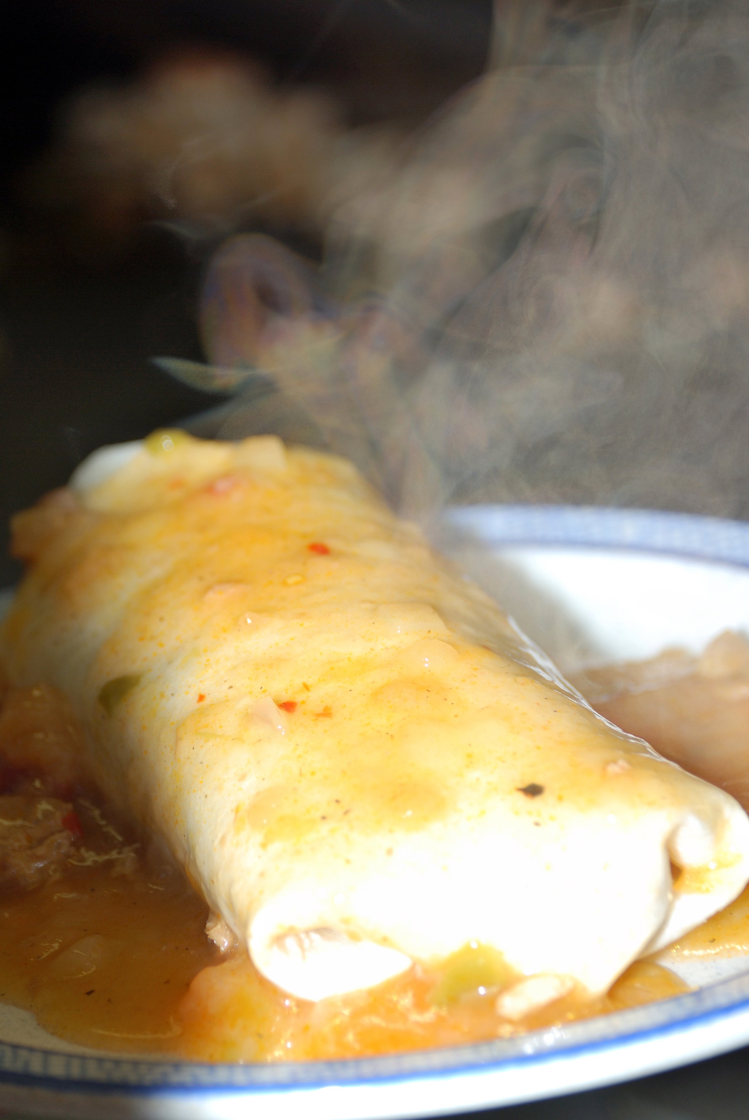 Up close steaming hot green chili burrito
