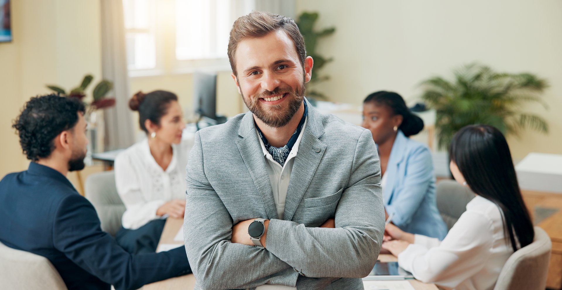 Portrait, business people and man with arms crossed, meeting and planning for profit increase. Face, leadership and manager with employees, smile and brainstorming for company culture or sales growth