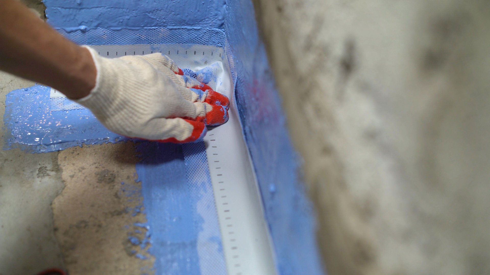 Proper placement of sealing tape, waterproofing tape in the first layer of waterproofing. Waterproofing tape in the bathroom. Applying a waterproofing tape to the joint between the wall and the floor. Internal construction works.