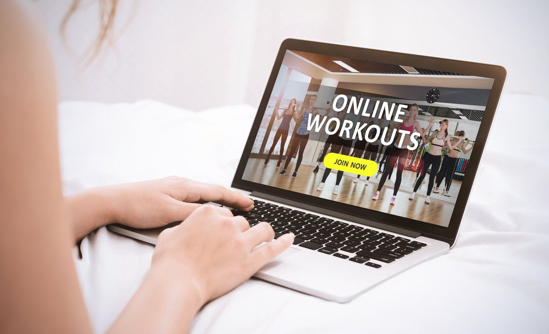 Online Workouts Concept. Back view of woman using laptop, browsing fitness and sport blog, looking at website