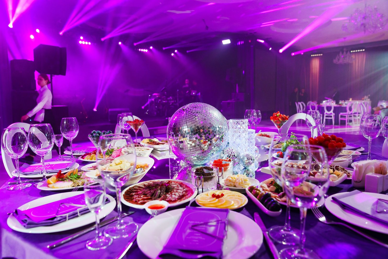 A table set for the holiday in purple in a dark banquet hall. Themed party. services of a professional decorator for a holiday.