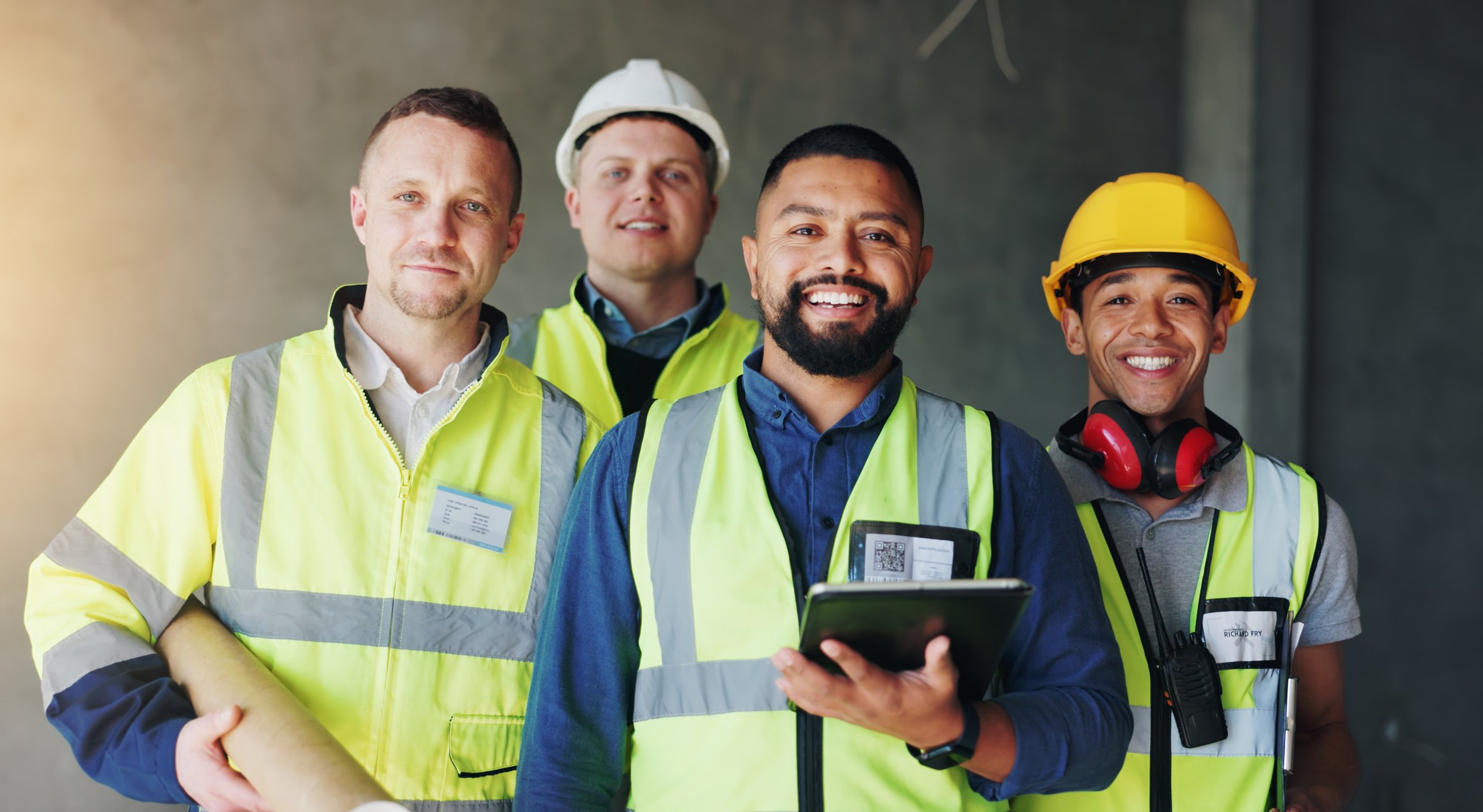 Men, team and portrait at construction site, happy and tablet for planning, renovation or blueprint for job. Group of people, builder and engineer for architecture project, smile or pride in industry