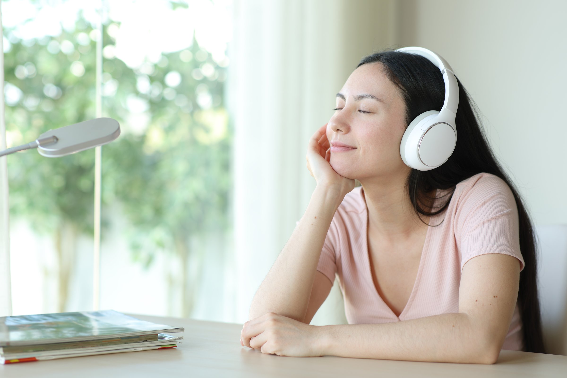 Asian woman relaxing listening audio with headphone at home