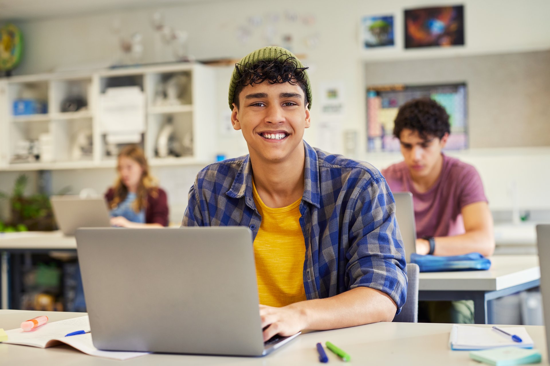 Hispanic student studying on laptop in classroom