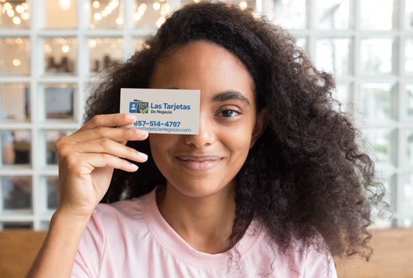 Hand holding blank white card on wooden background