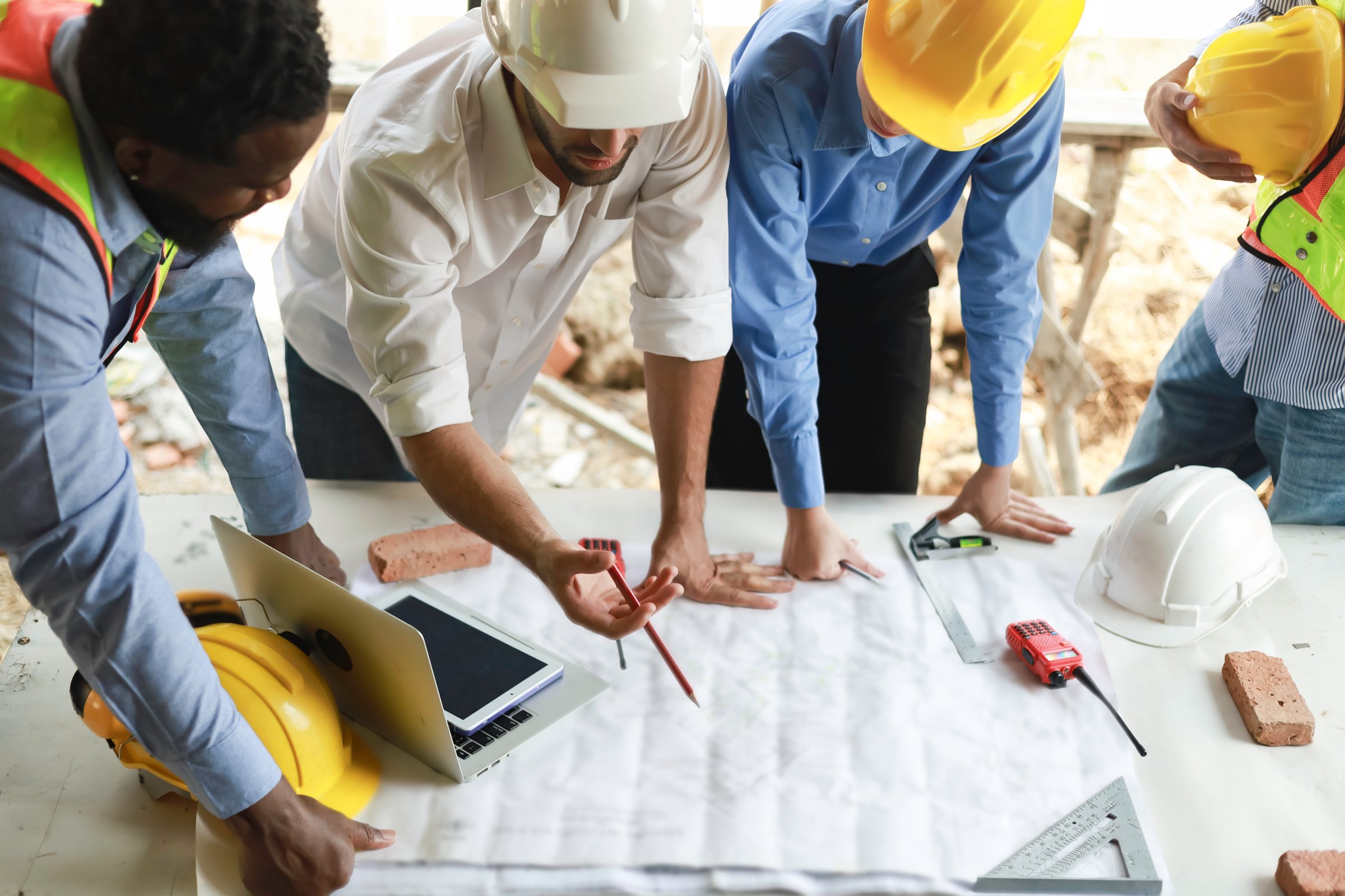 A group of engineers and staff met to discuss and work together to assess the progress of the residential construction site.
