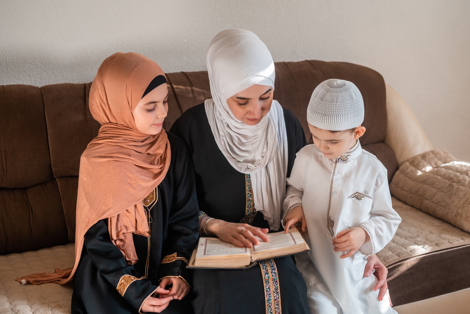 A happy Muslim family reading a Quran at the home. High quality photo