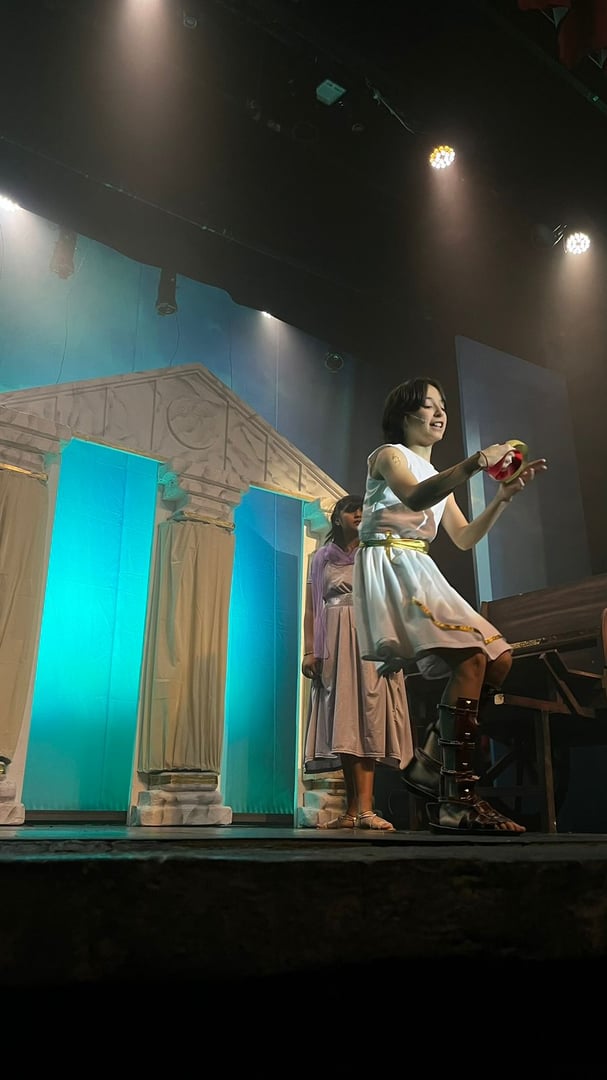 Little girl is dancing in a clown costume. The child performs on stage.