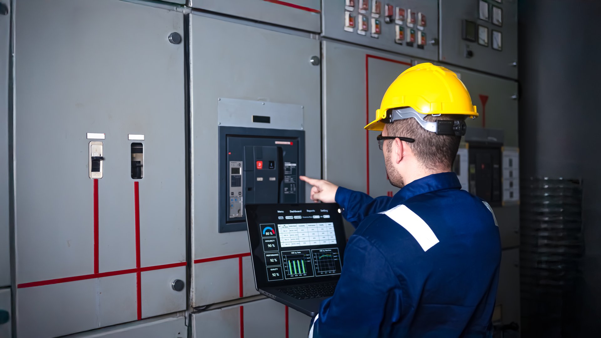 Electrical engineer check the operation of the main electrical control panels and switches, record values on tablets, electrician inspect the electrical systems in the factory.