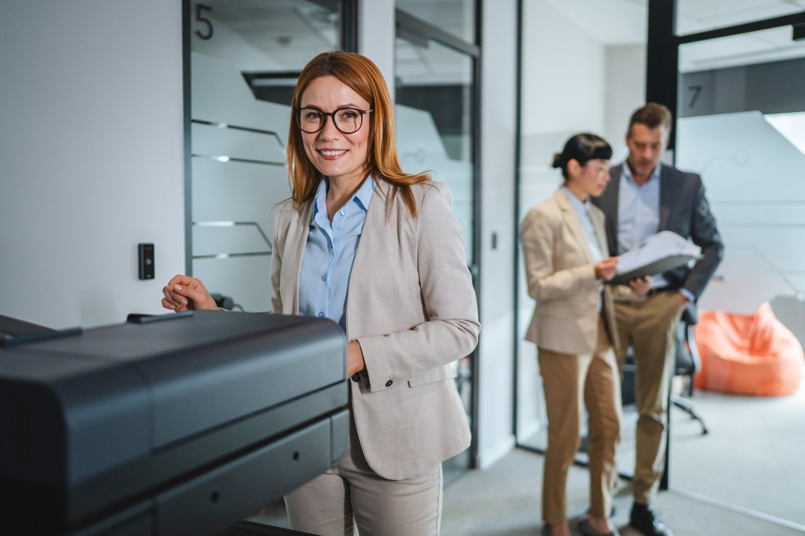 Adult caucasian businesswoman use photocopy machine in hallway of company