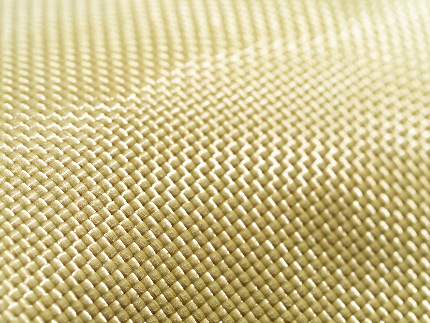 Selective focus. Bulletproof material aramid. Shining aramid kevlar background. Yellow kevlar texture and pattern.