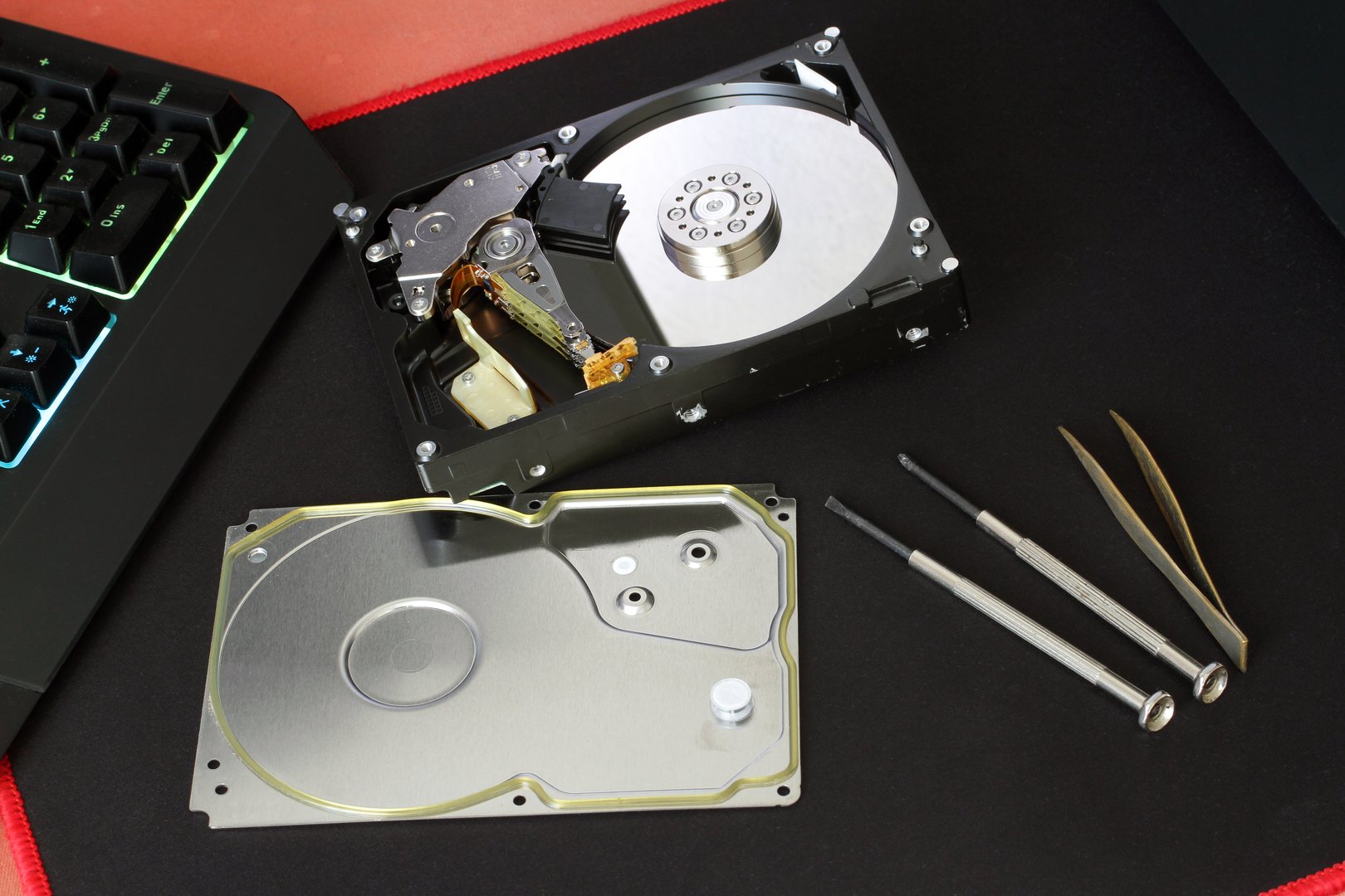 A disassembled computer hard drive on a computer desk. Repair of computer components.