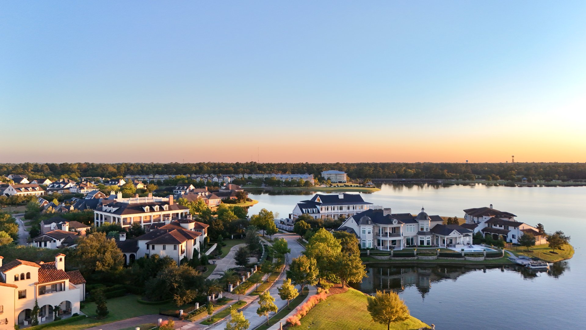 Aerial view of a peaceful lake at sunset  with luxurious houses by Woodlands lake , Houston, Texas.
