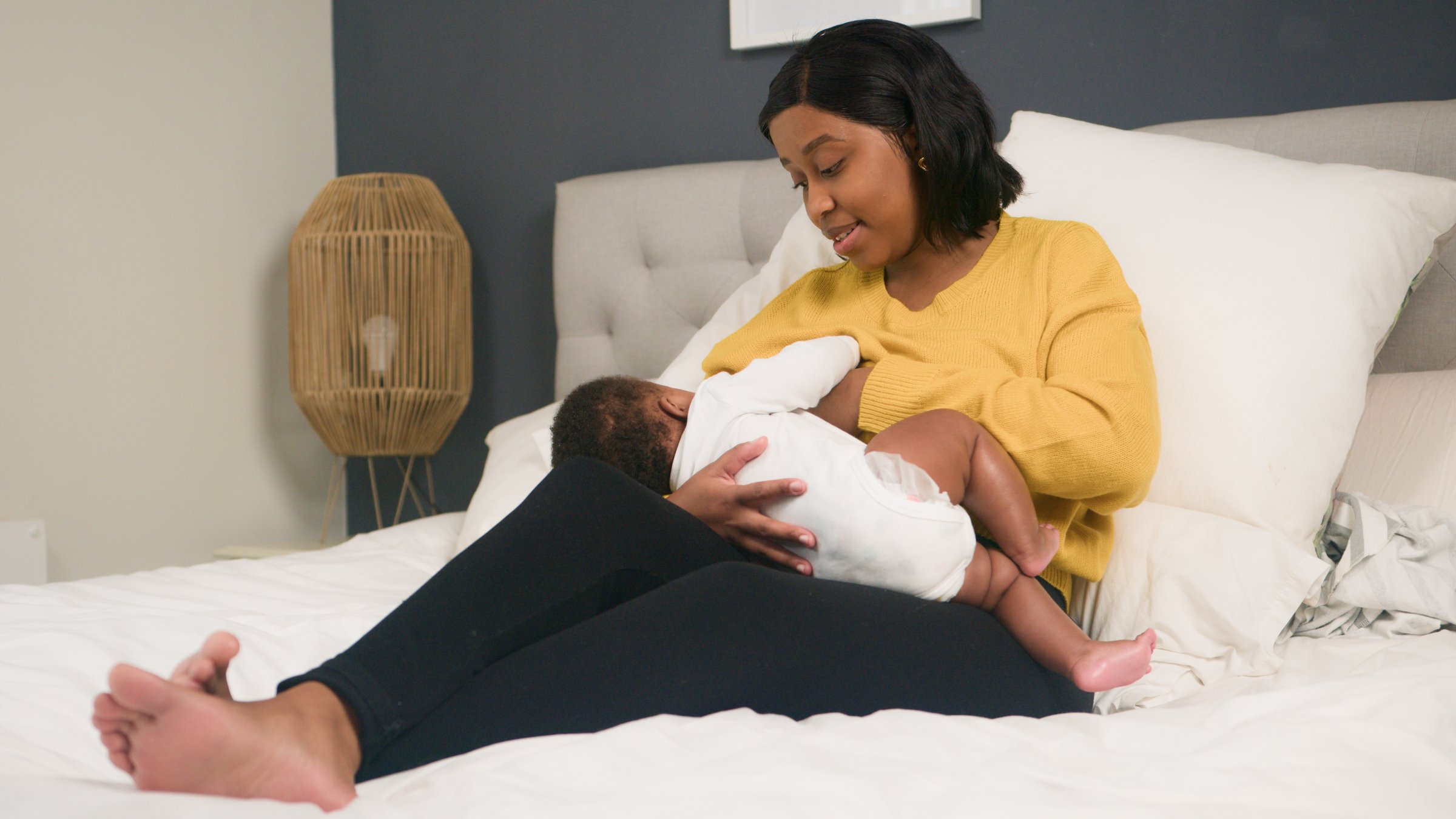 A tender moment as a mother cares for her baby in a tranquil home setting. She lovingly breastfeeds her child, symbolizing motherhood, bonding, and natural care within a warm and comfortable environment.