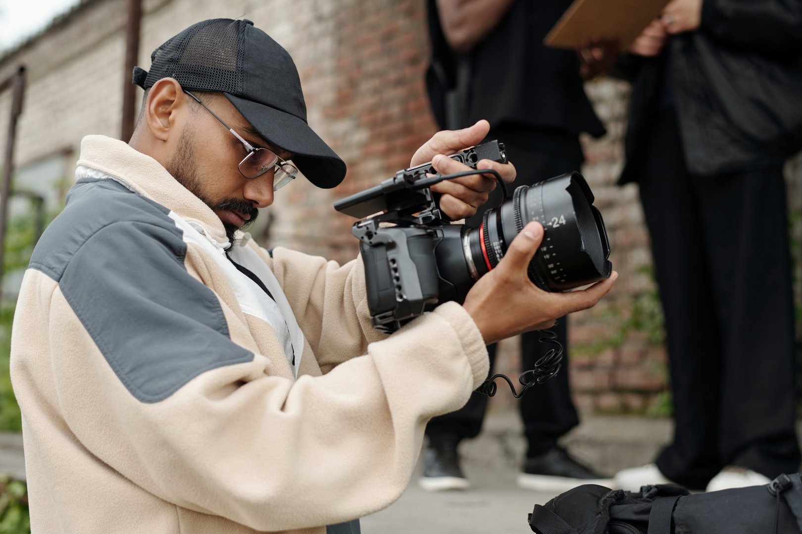Man operating a professional video camera outdoors capturing detailed footage of surroundings engagement in precise angle adjustments and focus settings in an urban environment