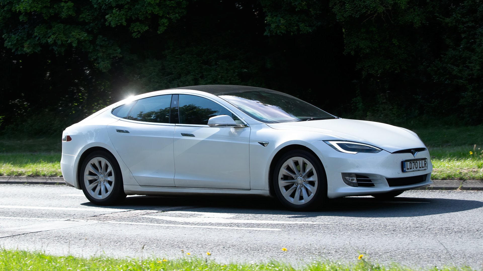 Milton Keynes,UK - July 18th 2024: 2020 white Tesla Model S long range electric car driving on a British country road