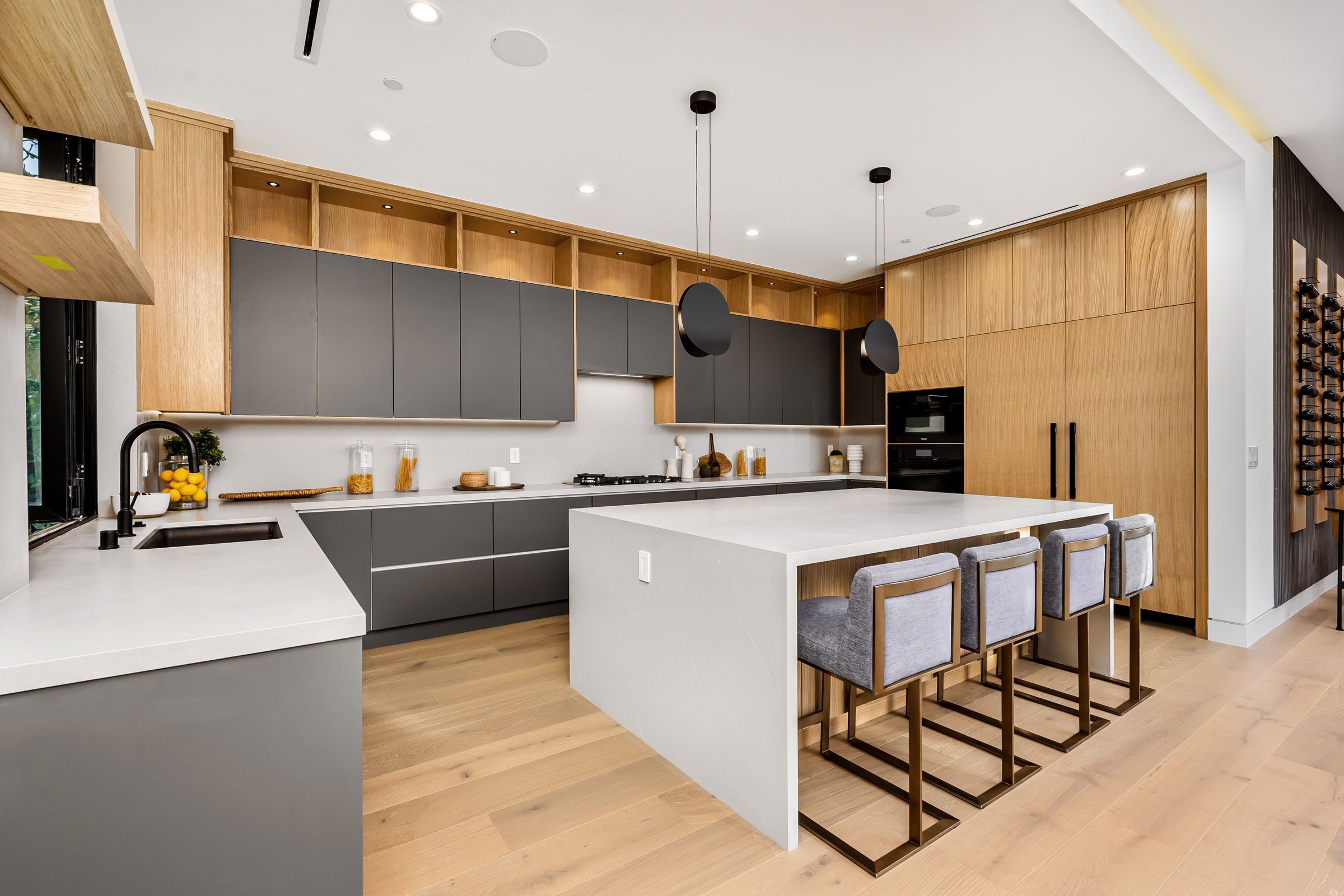 Modern kitchen interior with a large island, sleek cabinetry, and stylish pendant lights.