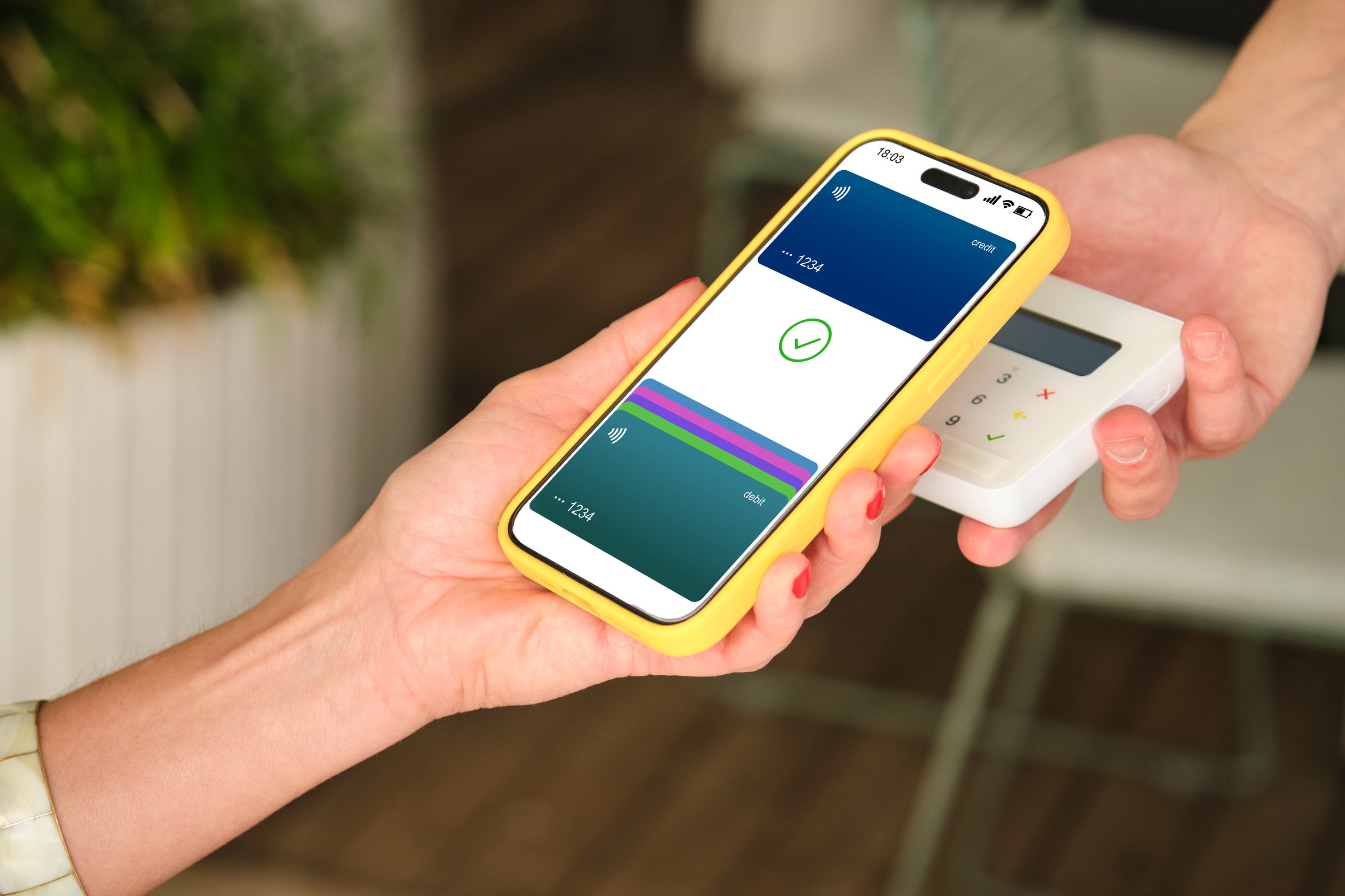 Hands holding smartphone with NFC technology for contactless payment in a store