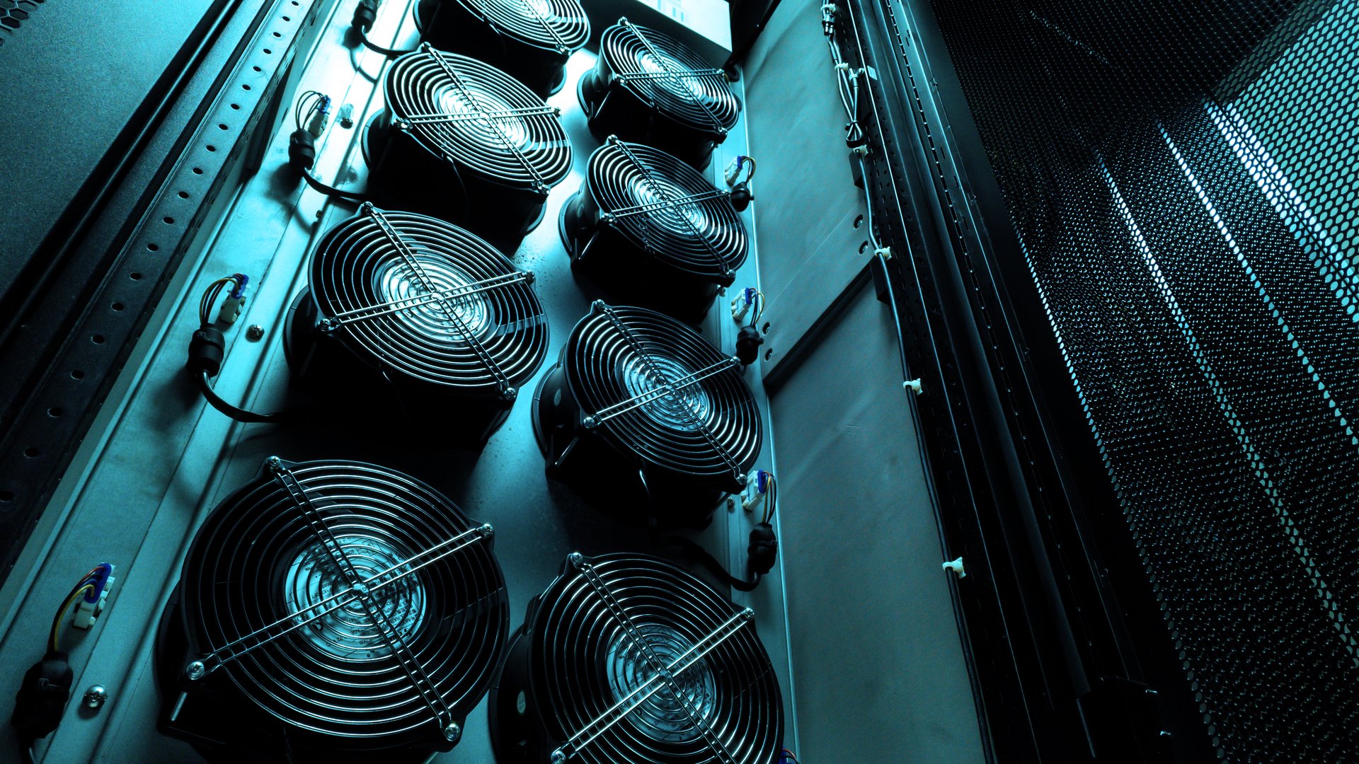 This image shows a close-up view of a server rack featuring multiple cooling fans. The interaction of technology and design highlights essential aspects of data center efficiency.