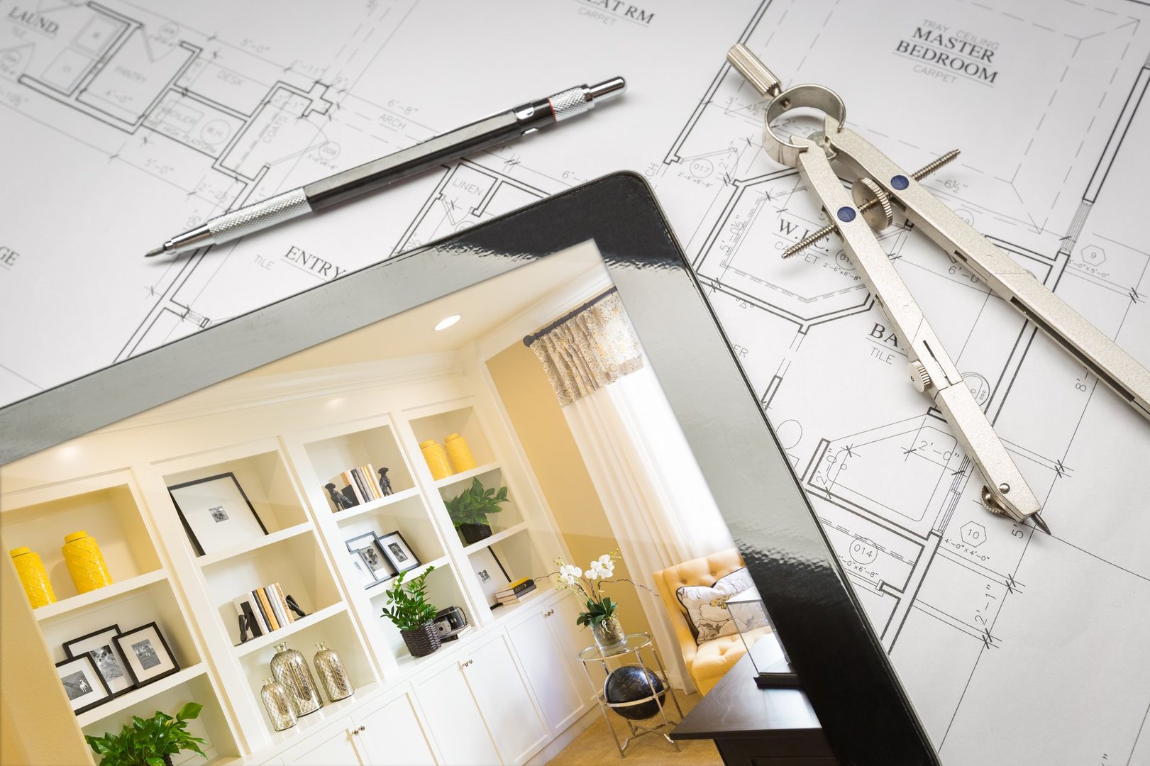 Computer Tablet with Finished Built-in Shelves and Cabinets Over House Plans, Pencil and Compass.