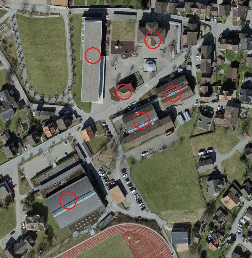 Aerial view of a residential area with several buildings and red circles highlighting specific locations.