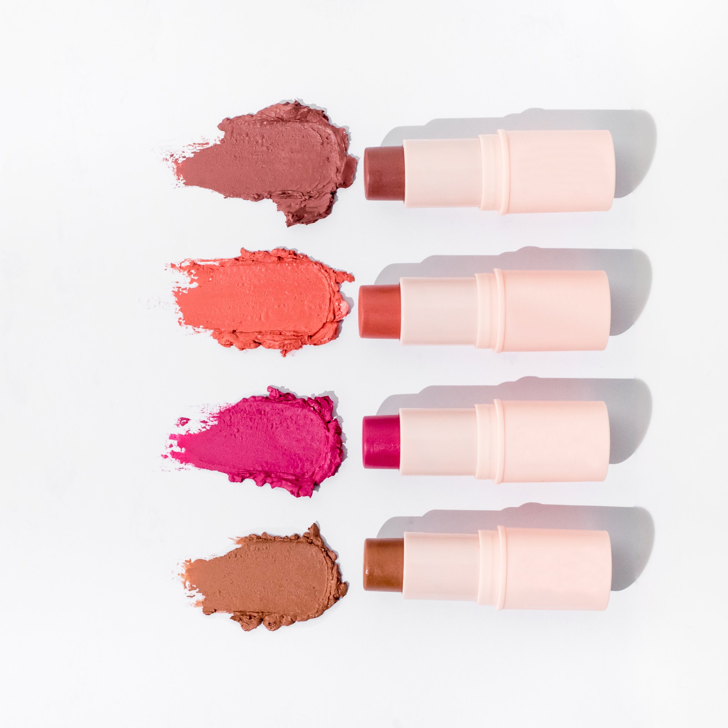 A row of collection of smudged lipticks with texture on isolated white, cosmetic blog cover