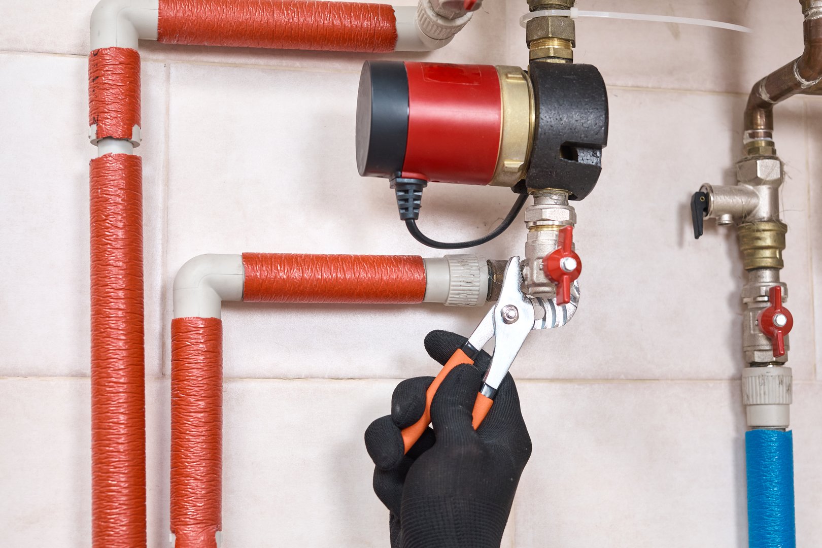 Plumber installing and connecting a water circulation pump