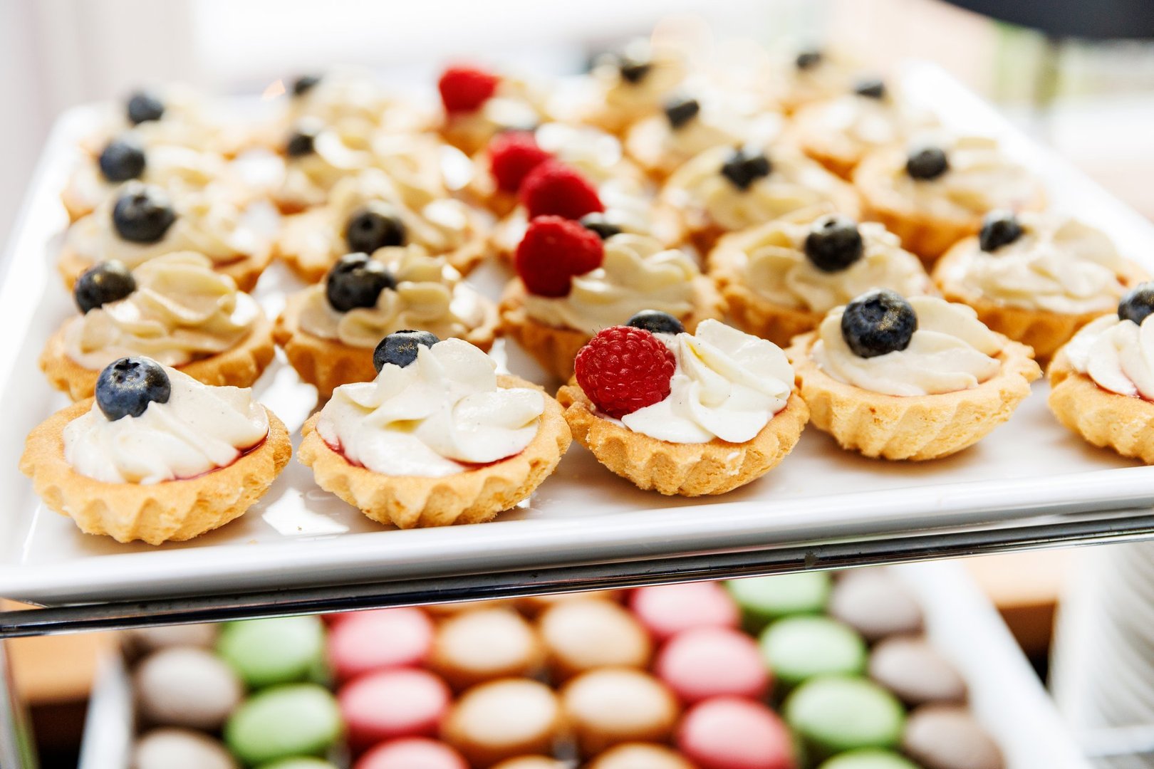 The set of mini tartlets topped with luscious cream and ripe berries