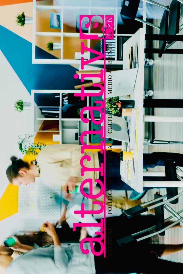 A modern office space with colorful walls, two people working at desks, and shelves in the background.