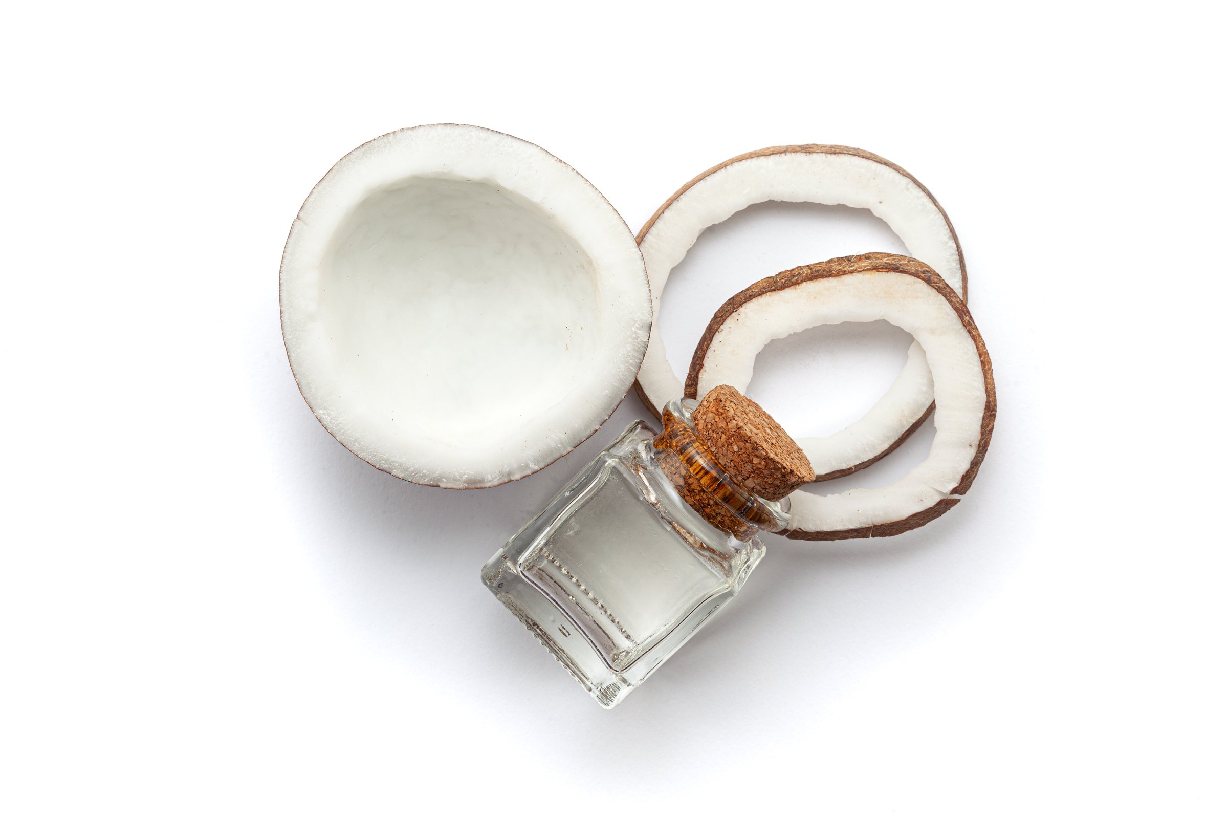 Top view of Fresh coconut fruit with coconut oil in a glass bottle. Isolated on a white background.