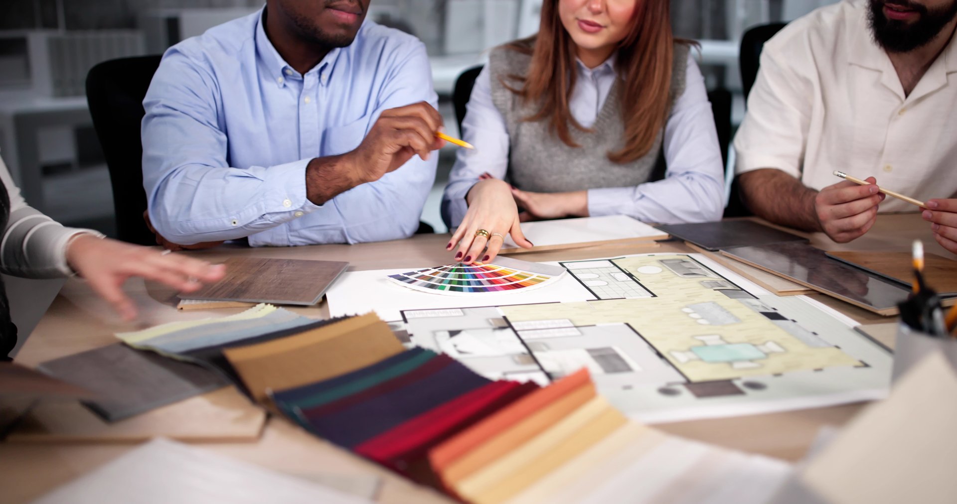 Designer Group At Desk Discussing Custom House Remodel
