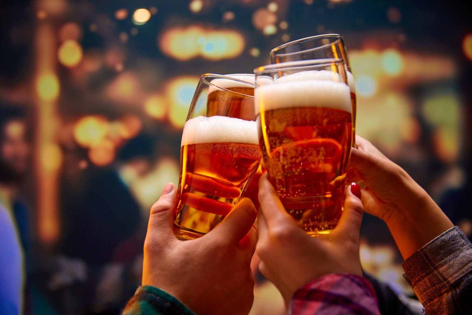 Close up shot of unrecognizable group of friends saying toasts and drinking beer and clinking glasses in bar while watching match. Concept of Beer  Fest, party, celebration, national traditions.