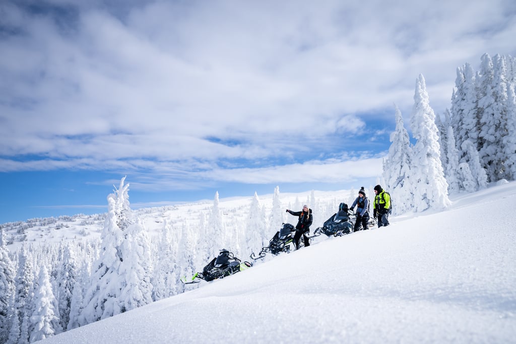 Extreme snowmobile rider carving through deep mountain powder