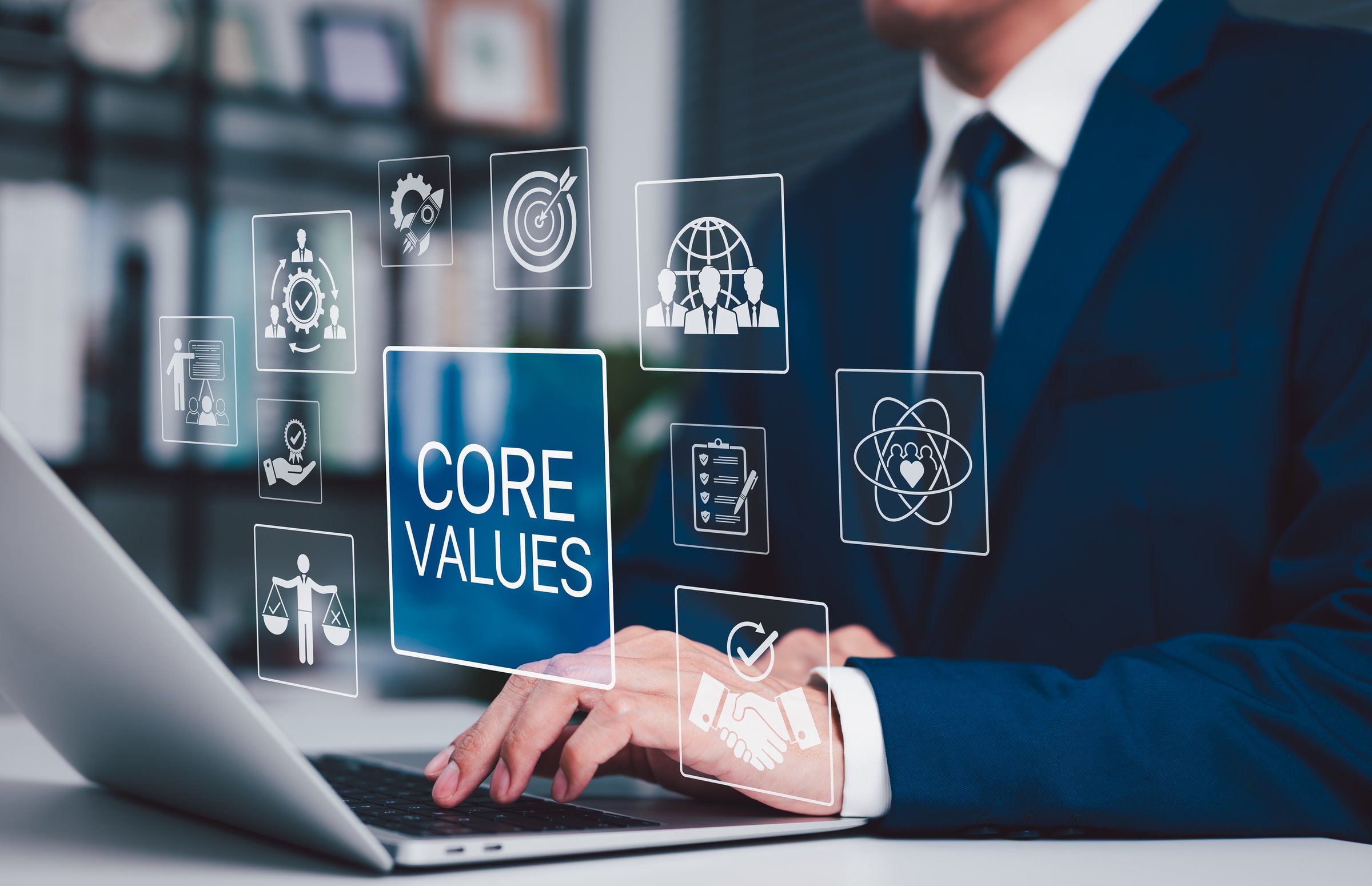 Business Core Values and Corporate Culture Concept. Businessman working on laptop with core values icons, ethics, teamwork, integrity, corporate mission, organizational culture and business principles