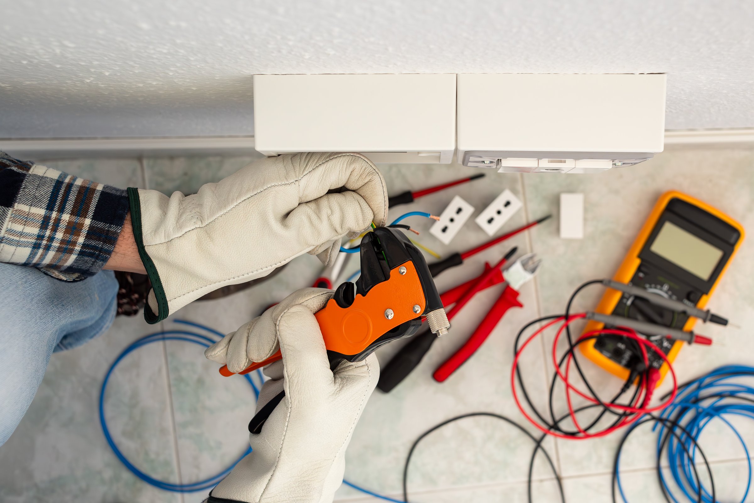 Electrician worker at work with wire stripper pliers