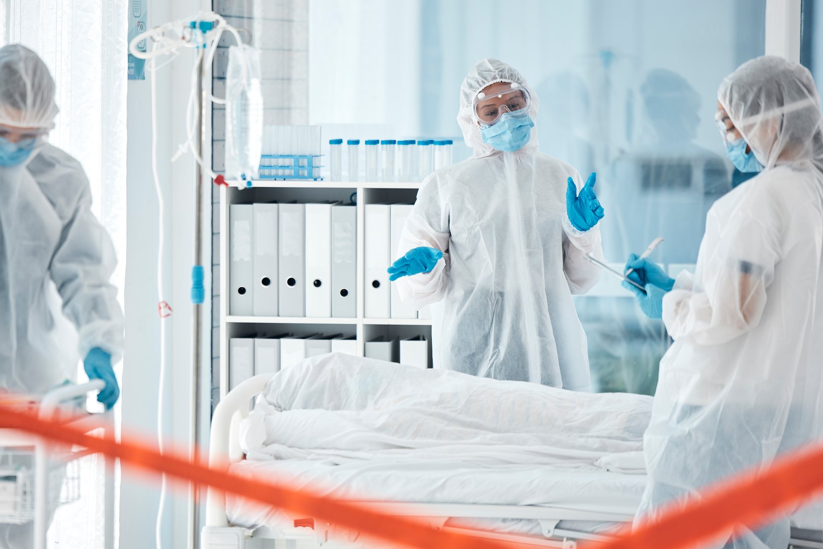 Healthcare, covid and doctors with ppe for safety, health and  compliance in a hospital with dead patient while staff takes notes of time. Medical workers in covid 19 unit for emergency virus