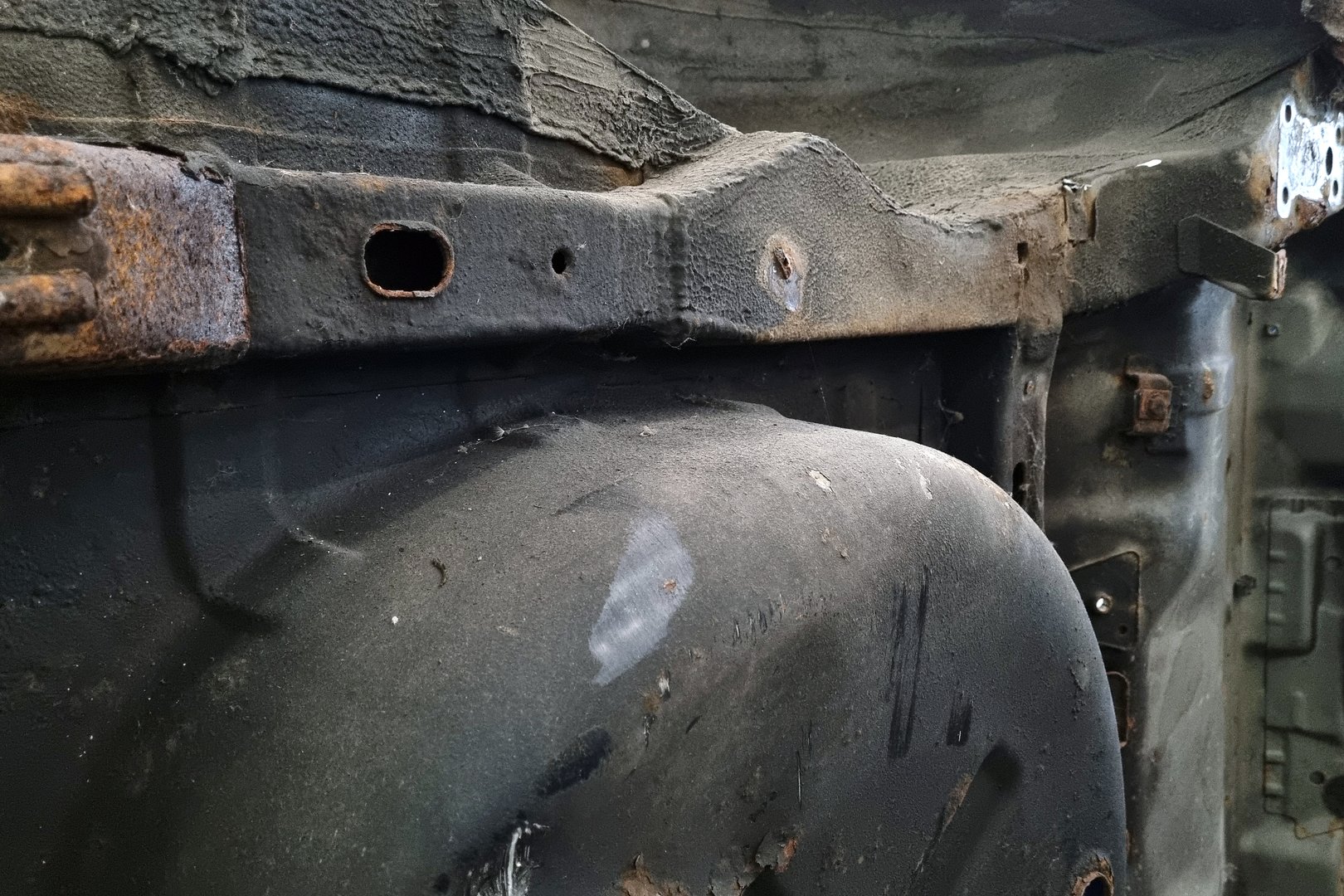 Close-up view of a rusty vehicle undercarriage showcasing aged metal and corrosion. the texture and colors emphasize the impact of time and elements on automotive components, ideal for restoration and repair concepts.