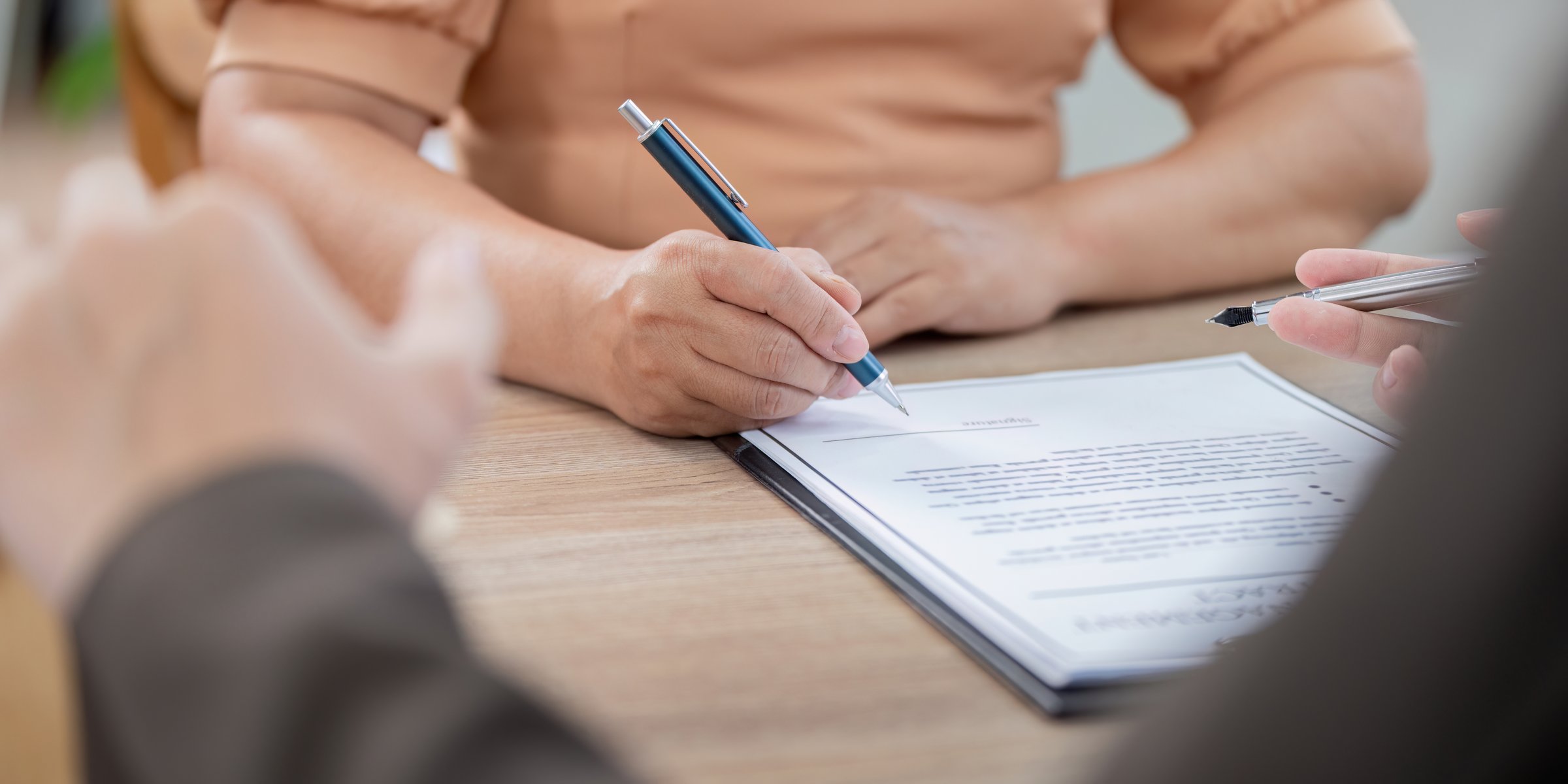 A real estate agent assists a client during the property contract signing process, focusing on legal accuracy and understanding.