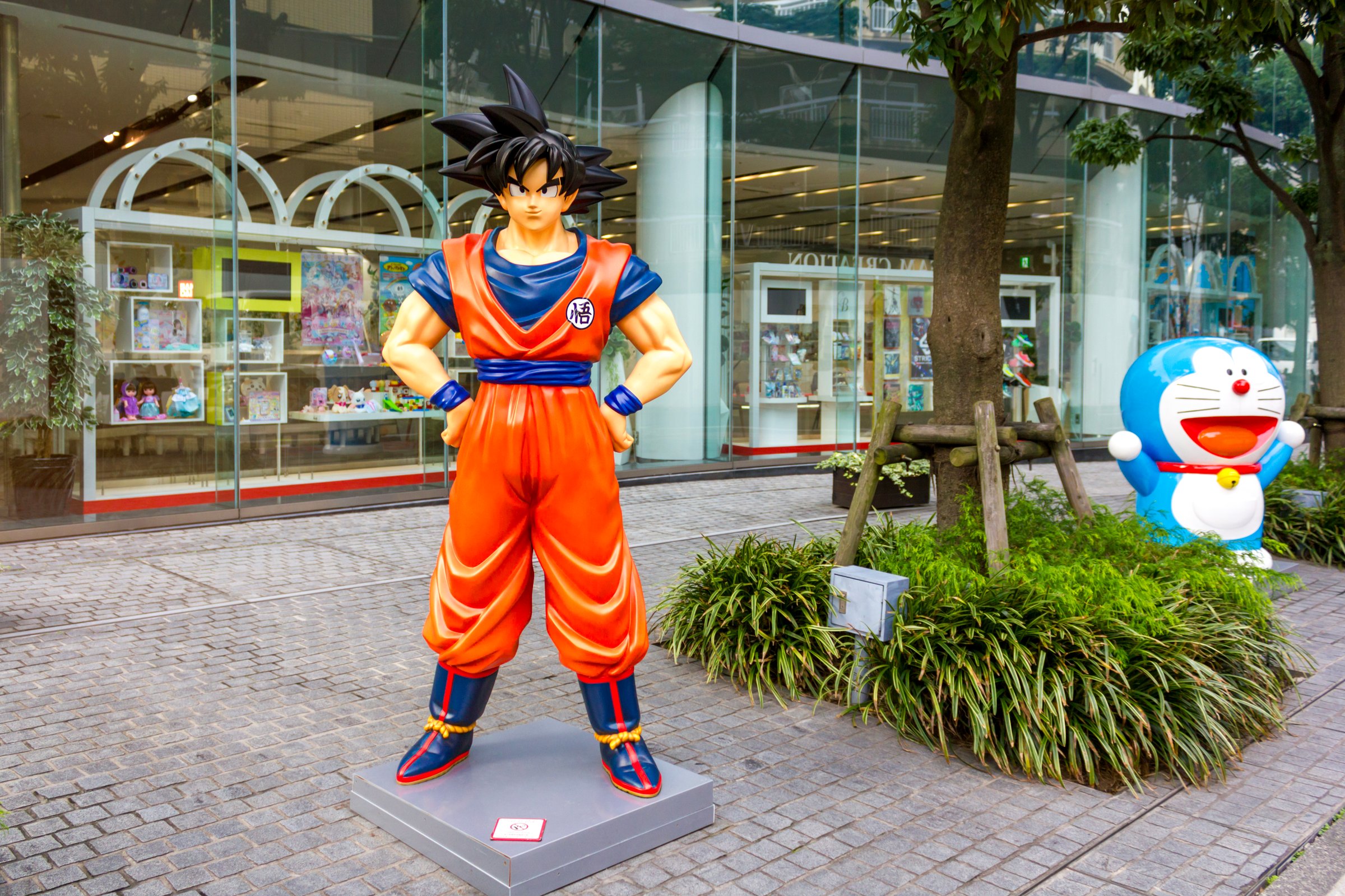 Tokyo, Japan - November 15, 2024: A life-sized statue of Goku from the anime 'Dragon Ball' and Doraemon from the iconic Japanese series 'Doraemon,' displayed outside a Bandai Namco toy store in Tokyo, Japan.
