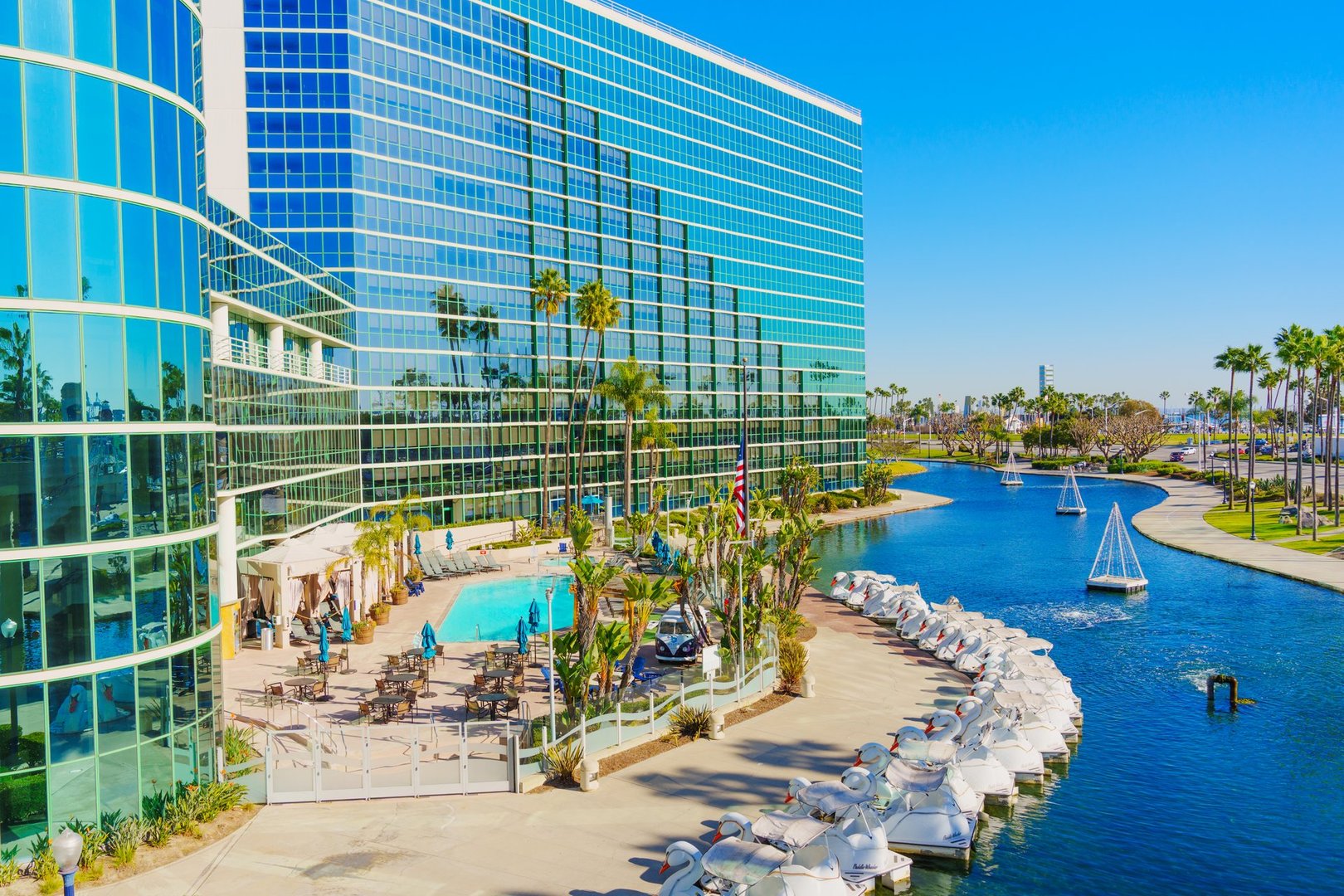 Long Beach, California - January 15, 2025: Aerial perspective of the Hyatt Regency featuring pool area and adjacent waterway with sailboats under clear skies.